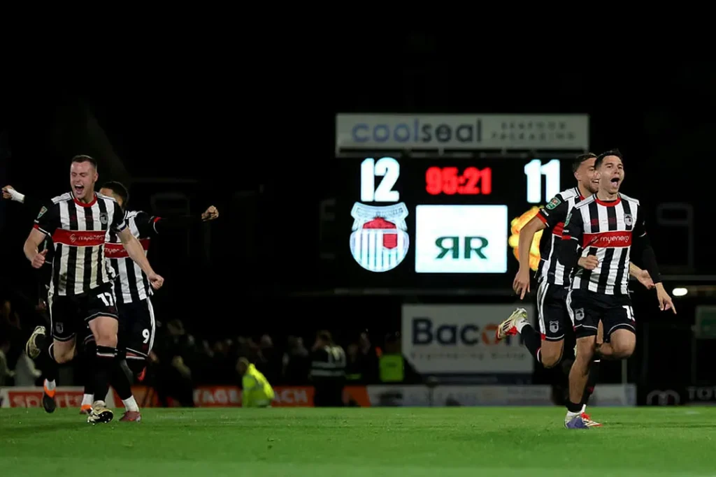 The EFL Cup second round delivered a dramatic upset as Grimsby Town eliminated Manchester United F.C. on penalties at Blundell Park on August 28, 2024. The grimsby town vs manchester united f.c. lineups proved decisive, with tactical rotation and defensive structure shaping the contest. Despite United racing into a 2-0 lead inside 30 minutes, Grimsby responded with an 89th-minute equaliser before winning 12-11 in a marathon shootout. As highlighted by The London Magazine, the result offered a clear tactical blueprint for how lower-league sides can challenge Premier League opposition in domestic cup competition. Match Overview & Key Details This EFL Cup second round fixture showcased the unpredictable nature of domestic cup competitions, where tactical preparation and mental fortitude can level the playing field between divisions. Manchester United arrived at Blundell Park with a heavily rotated squad, while Grimsby Town deployed their strongest available lineup in pursuit of a historic result. The grimsby town vs manchester united f.c. lineups revealed contrasting approaches: Erik ten Hag opted for wholesale changes to manage squad workload, while Grimsby manager Paul Hurst fielded a full-strength side with tactical modifications designed to exploit United's rotation policy. Match Summary: Competition: EFL Cup Second Round Venue: Blundell Park, Cleethorpes Date: August 28, 2024 Full-Time Score: 2-2 (after extra time) Penalty Score: 12-11 (Grimsby Town won) Attendance: 9,052 First Goal: Manchester United (22') Second Goal: Manchester United (30') Equalizer: Grimsby Town (89') The tactical narrative of this encounter shares similarities with other recent cup upsets in English football. Much like the drama documented in our Aston Villa vs Newcastle FA Cup match report, this fixture demonstrated how tactical adjustments and psychological momentum can overcome perceived quality gaps in knockout football. Confirmed Grimsby Town F.C. Lineup & Formation Grimsby Town deployed a disciplined 4-1-4-1 formation designed to compact central areas and force Manchester United into wide positions where their rotated squad lacked cohesion. Manager Paul Hurst selected his most experienced players for this high-profile fixture, prioritizing defensive solidity while maintaining counter-attacking threat. Starting XI (4-1-4-1): Position Player Name Key Role GK Jordan Wright Distribution and penalty hero RB Harvey Rodgers Defensive discipline CB Luke Waterfall Aerial dominance CB Doug Tharme Recovery defending LB Denver Hume Progressive passing DM Gavan Holohan Defensive screen RM Kieran Green Work rate and pressing CM Donovan Wilson Box-to-box energy CM Charles Vernam Creative link LM Harry Clifton Counter-attacking width ST Danny Rose Target man hold-up play Tactical Setup & Player Roles The grimsby town vs manchester united f.c. lineups comparison revealed Grimsby's intelligent tactical setup focused on limiting space between defensive and midfield lines. Gavan Holohan's positioning as the defensive midfielder proved crucial, screening the back four and disrupting United's attempts to play through central areas. The wide midfielders Kieran Green and Harry Clifton maintained disciplined positions, rarely venturing ahead of the ball in the first half to prevent counter-attacking exposure. Danny Rose's role as the lone striker required exceptional physical endurance and intelligent movement. His hold-up play provided the foundation for Grimsby's counter-attacks, while his tireless pressing forced errors from United's inexperienced defenders. The tactical approach demonstrated sophisticated match preparation, with Grimsby's coaching staff clearly identifying vulnerabilities in United's rotated backline. Confirmed Manchester United F.C. Lineup & Formation Manchester United manager Erik ten Hag implemented a 3-4-2-1 formation featuring nine changes from the previous Premier League fixture. This tactical system aimed to provide defensive stability through three center-backs while offering attacking width through wing-backs. However, the lack of familiarity between rotated players created cohesion issues that Grimsby exploited in the second half. Starting XI (3-4-2-1): Position Player Name Competition Debut/Rotation GK Altay Bayındır First EFL Cup start CB Harry Maguire Rotation opportunity CB Jonny Evans Experience anchor CB Victor Lindelöf Left-sided center-back RWB Diogo Dalot Attacking outlet CM Casemiro Midfield leadership CM Christian Eriksen Creative distribution LWB Tyrell Malacia First start of season CAM Bruno Fernandes Captain and playmaker CAM Antony Goal threat ST Marcus Rashford Pace and finishing Tactical Setup & Rotation Analysis The grimsby town vs manchester united f.c. lineups showed how Manchester United’s rotation created both opportunities and risks. Their 3-4-2-1 system aimed to control central areas, with Casemiro and Christian Eriksen managing possession and Bruno Fernandes and Antony operating between the lines. Marcus Rashford led the attack to exploit space against Grimsby’s compact defensive block. However, the back three of Maguire, Evans, and Lindelöf struggled with transitions, while Bayındır’s limited match rhythm and Malacia’s rust exposed the flanks. Early goals masked these weaknesses, which became clear as Grimsby grew into the match. Key Substitutions & Game-Changing Moments Substitutions had a decisive impact. Manchester United brought on Alejandro Garnacho, Mason Mount, and Joshua Zirkzee between the 60th and 75th minutes to boost attack, but defensive frailties remained. Grimsby’s changes were more effective: Luca Barrington added direct running, Jayden Luker refreshed the wide areas, and Jordan Davies played a key role in the 89th-minute equalizer. These moves exploited United’s tired and rotated players, shifting momentum in favor of Grimsby and setting the stage for extra time and the dramatic penalty shootout. Match Statistics Comparison The statistical analysis reveals how Grimsby's tactical discipline neutralized Manchester United's technical superiority. While United dominated possession and shot count, the quality of chances remained relatively equal, particularly after halftime adjustments. Statistic Grimsby Town Manchester United Possession 37% 63% Total Shots 11 18 Shots on Target 6 7 Corners 4 9 Fouls Committed 14 8 Pass Completion 68% 81% Goals Scored 2 2 Penalty Conversion 12/12 11/12 The possession differential reflects the expected pattern given the divisional gap, yet Grimsby's efficiency in transition created genuine scoring opportunities. The shots on target statistic demonstrates clinical finishing from both sides within the run of play, while the penalty shootout statistics reveal exceptional nerve from Grimsby's players under immense pressure. The foul count indicates Grimsby's physical approach disrupted United's rhythm without crossing into reckless territory. Tactical Breakdown - Why the Result Happened The result stemmed from several tactical factors over 120 minutes. Manchester United started strong as Grimsby opened cautiously, allowing space for their technical players to exploit. The 22nd and 30th-minute goals came from individual errors rather than systemic flaws, giving United a false sense of control. At halftime, Grimsby's coaching staff adjusted pressing triggers, shifting from passive defending to aggressively engaging United’s center-backs. This disrupted build-up play and allowed Grimsby’s fresher defenders to exploit space. The grimsby town vs manchester united f.c. lineups highlighted United’s lack of defensive security under sustained pressure. Manchester United’s continued use of the 3-4-2-1 system, combined with attack-focused substitutions, left wing-backs exposed. Grimsby capitalized with their late equalizer, showcasing how tactical discipline and rotation awareness can overcome higher-quality opposition. As noted by The London Magazine, these moments underscore the risks of rotation policies that compromise squad cohesion in knockout competitions. Player Performances & Standout Statistics Individual performances ultimately decided this dramatic encounter, with several players exceeding expectations under pressure. For Grimsby Town, goalkeeper Jordan Wright delivered a masterclass in penalty psychology, saving the decisive spot-kick after 23 successful conversions. His positioning and timing demonstrated professional-level technique that belied his League Two status. Danny Rose's physical performance statistics highlighted his importance to Grimsby's tactical plan. The striker contested 18 aerial duels, winning 11, while completing 23 passes with 65% accuracy despite constant defensive attention. His tireless running forced Manchester United's center-backs into uncomfortable positions throughout the match, creating the space for teammates to exploit in transition. For Manchester United, Bruno Fernandes' creative statistics showed individual quality that couldn't translate into team success. The captain created five chances, completed 89% of his passes, and maintained constant movement between lines. However, the grimsby town vs manchester united f.c. lineups revealed limited support from less experienced teammates unable to match his intensity and decision-making quality over 120 minutes. Marcus Rashford's finishing secured United's early advantage, but his 31 touches over 120 minutes illustrated the service issues created by disjointed team performance. The striker's isolation reflected broader tactical problems that Grimsby's compact defensive structure exploited effectively. The contrast between individual brilliance and collective dysfunction ultimately determined Manchester United's elimination. Squad Depth Comparison The broader squad context explains why rotation policies carry inherent risks in cup competitions. The depth comparison reveals significant differences in experience and international pedigree between the two squads. Category Grimsby Town Manchester United Average Squad Age 26.3 years 25.8 years International Players 2 18 Foreign Players 4 21 Average Market Value £1.2M £42M League Position (Previous Season) 19th (League Two) 8th (Premier League) Despite the massive financial disparity, Grimsby's squad cohesion and match rhythm advantages proved decisive. The home side fielded players with consistent minutes and established on-field relationships, while United's rotated lineup lacked the familiarity required for complex tactical execution under pressure. The analysis of grimsby town vs manchester united f.c. lineups demonstrate how squad harmony can temporarily overcome individual quality gaps in knockout football environments. What This Result Means Going Forward For Grimsby Town, this win brings financial reward, confidence, and validation of their tactical discipline. Beating higher-level opposition proves their structure and preparation can compete beyond League Two. For Manchester United, the defeat exposes concerns about rotation balance and squad cohesion. Heavy changes disrupted defensive organisation, and the lack of chemistry proved costly in a knockout setting. Mentally, Grimsby gained momentum for the rest of their season. United’s fringe players, meanwhile, missed a key opportunity to strengthen their first-team credentials. Conclusion The grimsby town vs manchester united f.c. lineups highlighted how organisation can overcome individual quality. United’s rotated side lacked defensive stability, while Grimsby’s compact 4-1-4-1 system delivered structure, resilience, and clinical execution when it mattered. The penalty shootout reflected superior composure from the home side, turning belief into a historic result. For Manchester United, this EFL Cup exit is a reminder that depth alone is not enough in knockout football — cohesion, tactical clarity, and mental sharpness remain decisive. Frequently Asked Questions What formation did Grimsby Town use against Manchester United in the EFL Cup? Grimsby Town deployed a disciplined 4-1-4-1 formation with Gavan Holohan as the defensive midfielder, prioritizing defensive compactness and quick counter-attacks against United's rotated lineup. Why did Manchester United lose to Grimsby Town despite leading 2-0? Manchester United's extensive squad rotation created defensive vulnerabilities and poor team cohesion. The inexperienced backline struggled with Grimsby's second-half pressing, ultimately conceding a late equalizer. Who scored the goals in the Grimsby Town vs Manchester United match? Manchester United scored twice in the first half (22nd and 30th minutes). Grimsby equalized dramatically in the 89th minute, forcing extra time and winning 12-11 on penalties. How many penalties were taken in the Grimsby Town vs Manchester United shootout? The penalty shootout required 24 total kicks, with Grimsby winning 12-11. Jordan Wright saved Manchester United's 12th penalty after both teams converted their first 11 attempts. What tactical changes did Grimsby Town make at halftime to improve performance? Grimsby adjusted their pressing triggers to engage United's center-backs higher up the pitch, disrupting build-up play and forcing defensive errors from the rotated backline throughout the second half.